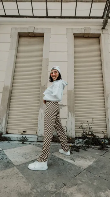 A woman in a white hoodie on a city street.